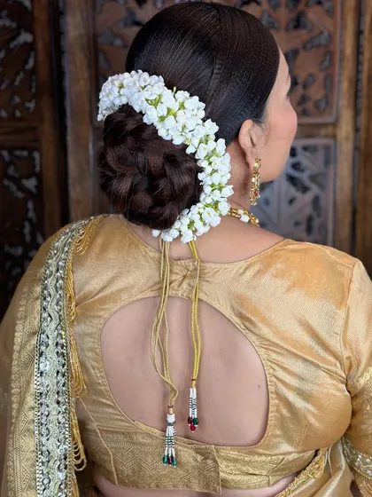 A classic, neat bridal bun encircled with a string of fresh jasmine flowers, perfect for a regal look.