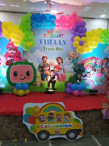 A full view of the Cocomelon stage, showing the colorful balloon arch and various character cutouts that bring the popular show to life.