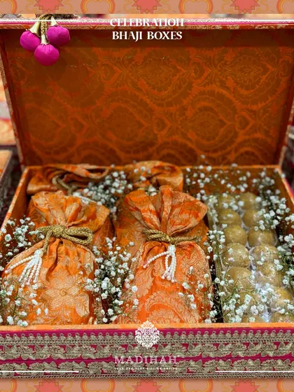 My Celebration Bhaji Boxes are designed to spread joy. This one, in a vibrant orange brocade, is filled with traditional sweets and snacks, perfect for any happy occasion.