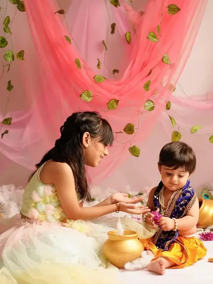 A tender moment between an older sister and her baby brother during their Radha Krishna photoshoot. These are the heartwarming interactions we love to document.