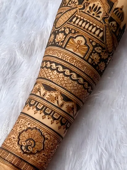 A close-up shot of the fine line work on a bridal forearm design. You can see the detail in the peacock and the delicate floral patterns.