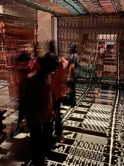 The students moving through the dark, atmospheric space of 'WEAVING LIGHT'.