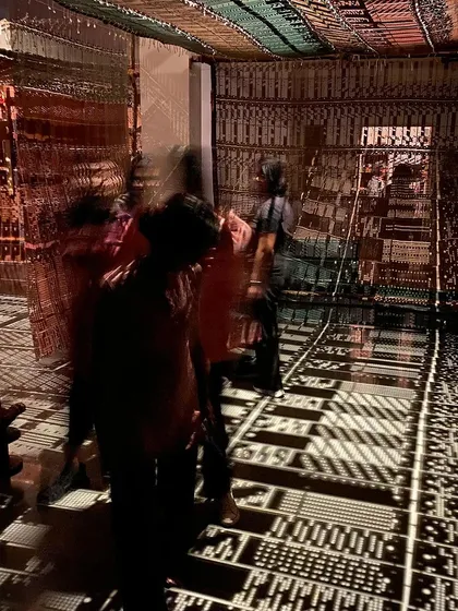 The students moving through the dark, atmospheric space of 'WEAVING LIGHT'.