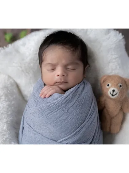 This little boy is sleeping so peacefully, swaddled in a soft blue wrap and accompanied by his teddy bear friend. I use simple, classic props that complement the baby without overwhelming the portrait.