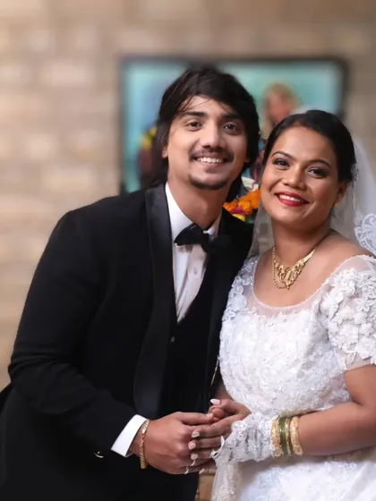 A lovely bride celebrating with her family. Her look features a classic red lip, which adds a beautiful pop of color against her white wedding dress, and a simple, elegant updo.