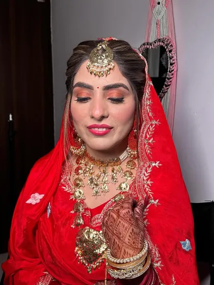 The complete look with her dupatta set. The eye makeup has a touch of orange and gold to match the details in her outfit.