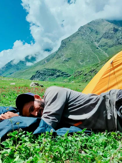 Taking a nap in the lap of nature. A trekker rests in a meadow in the Pin Parvati valley.