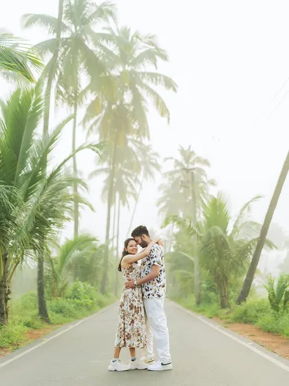 A happy, candid embrace on a misty morning in Goa. The towering palm trees create a stunning, tropical backdrop.