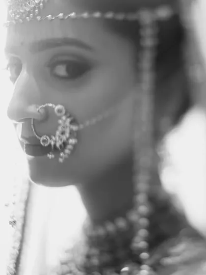 A soft and delicate black and white portrait. The shallow depth of field draws all the attention to the bride's eyes and her traditional nose ring.
