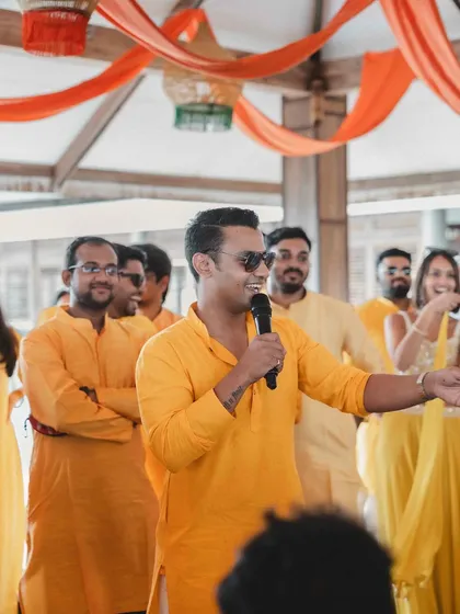 The groom's friends sharing a few words during a fun-filled Haldi ceremony at a destination wedding in Wayanad. We help coordinate speeches and performances to make the event personal.