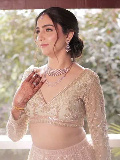 This bride is glowing. The soft, messy bun is a chic and modern choice for a wedding or reception, pairing beautifully with her diamond jewellery.