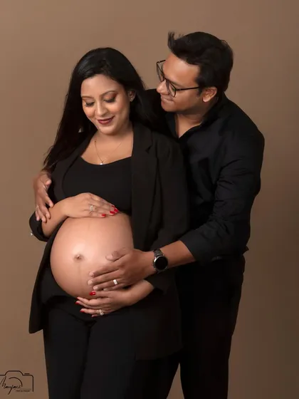 A loving portrait of the couple, both gently holding the baby bump. Their connection is the heart of this simple and beautiful photo.
