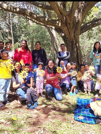 The whole gang posing with their sun-themed crafts! This group shot shows the pride and happiness of the children after a fun session of stories and creative activities.