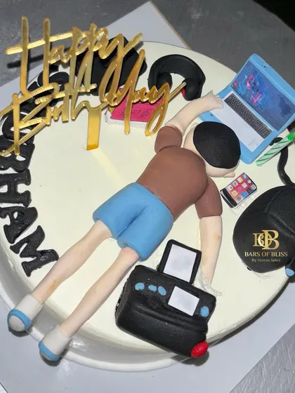 This fun, custom cake was designed for a client's birthday, showing a tired figure surrounded by a laptop and work items. It's a great example of how I can turn inside jokes into cake art.