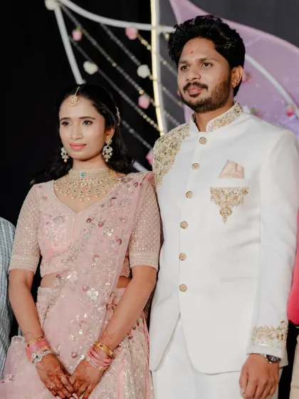 A full-length shot of the couple. Her makeup and hair are perfectly styled to match the elegance of her embroidered lehenga.