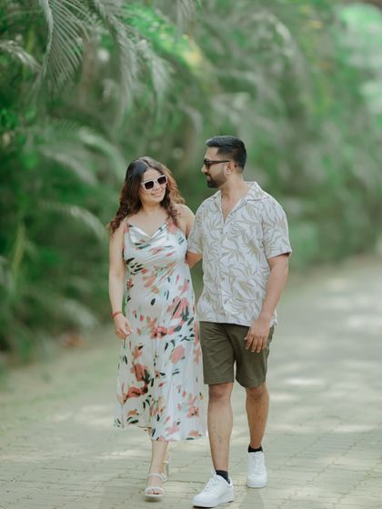A sweet, walking-and-talking shot of a couple in a tropical setting. Their smiles and easy-going posture show a comfortable and happy connection.