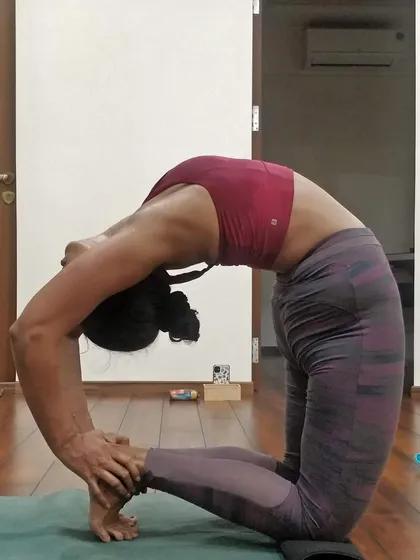 A student in a deep backbend during a masterclass. These workshops are a space for breakthroughs, where expert guidance helps you safely explore the limits of your practice.