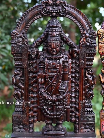 A close-up of the wax brown Tirupati Balaji statue, focusing on the intricate details of the arch and the deity's attire.