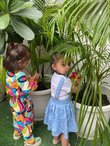 A moment of quiet curiosity in the garden. We provide ample opportunities for our little stars to interact with nature, fostering a sense of wonder and respect.