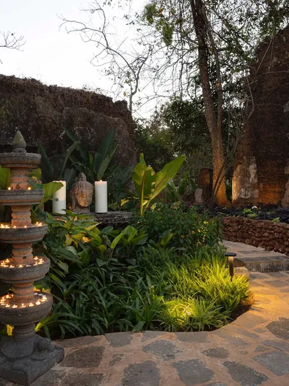 A stone pathway at Sanctuary Bar, illuminated by candles and traditional lamps. The design guides visitors through a sensory journey, with fragrant plants and the soft glow of light enhancing the experience.