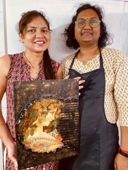A student and instructor proudly display a finished mixed-media canvas. Our one-day workshops are designed to help you complete a beautiful project in a single session.