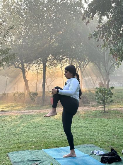 Preparing for a balancing pose in the serene atmosphere of the park.