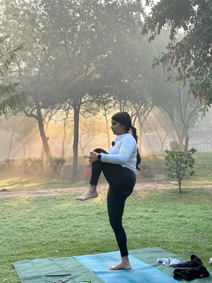 Preparing for a balancing pose in the serene atmosphere of the park.