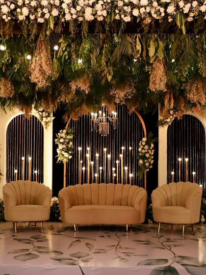 The central part of the stage, focusing on the comfortable seating and the romantic backdrop of hanging foliage and lights.