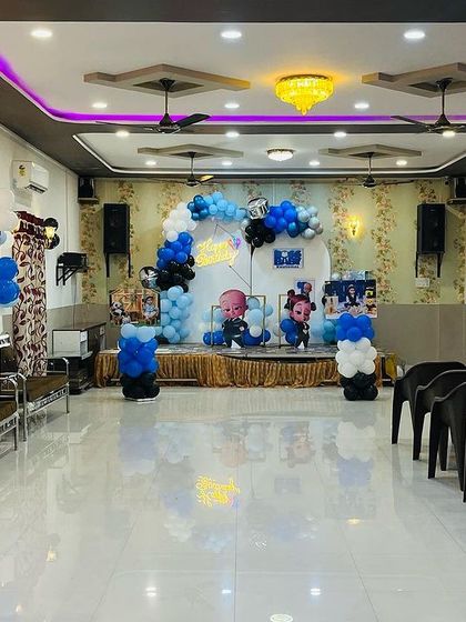 A wide view of a Boss Baby themed party in a banquet hall. This shows how we can decorate a large stage area to create a focal point for the celebration.