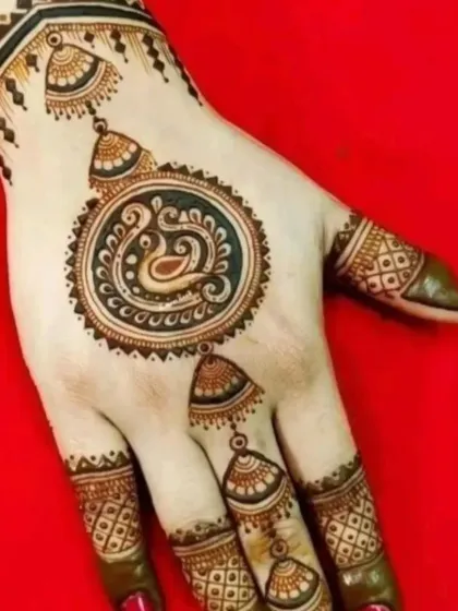 A chic and minimal back-hand design featuring a central swan motif with hanging jhumka elements. This is a great example of party mehndi that is both quick and beautiful.