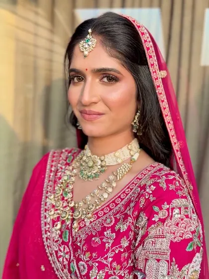 The final look, with the makeup perfectly complementing her traditional red lehenga and kundan jewelry.