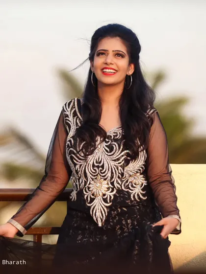 A happy, smiling portrait of the model in the black gown, with the wind gently blowing her hair.
