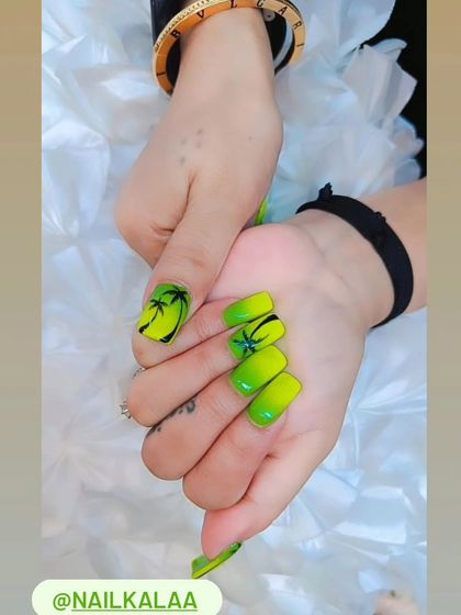A vibrant neon green ombre set, perfect for a tropical vacation, with hand-painted black palm tree silhouettes on the accent nails.