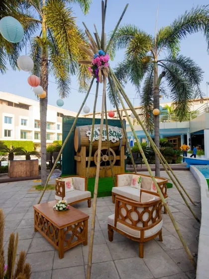 A rustic-chic seating area at the carnival, featuring a teepee-style bamboo structure and comfortable wooden furniture.