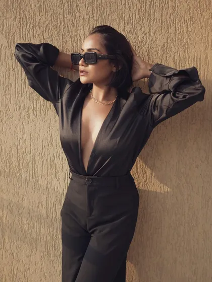The 'Boss Lady' concept brought to life. This image of model Swati Shepherd in a plunging black suit and sunglasses captures a powerful, confident, and professional aesthetic, perfect for personal branding.