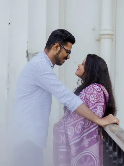 A romantic portrait of the couple against a white architectural backdrop. The soft, dreamy foreground adds an artistic touch.