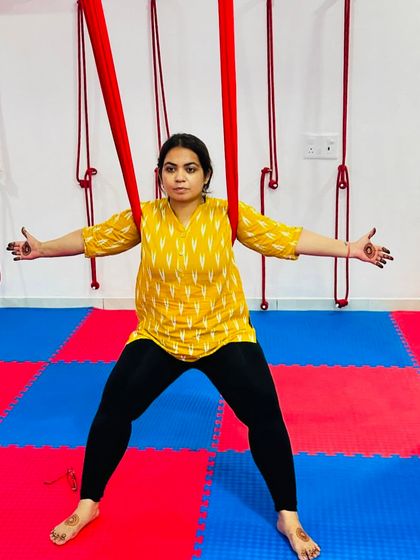 Finding your footing in the hammock is the start of an exciting journey. This student prepares to move into a new pose, demonstrating focus and readiness.