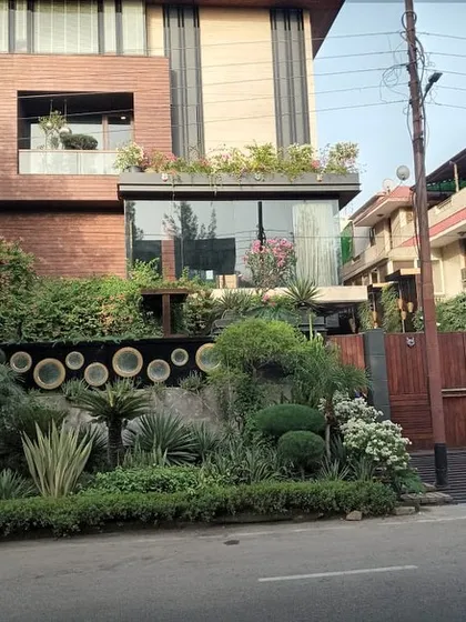 This Noida residence showcases how landscaping can be integrated with modern architecture. I designed and installed multi-level greenery, including rooftop gardens, balcony planters, and a dense, sculpted front yard to complement the home's unique facade.