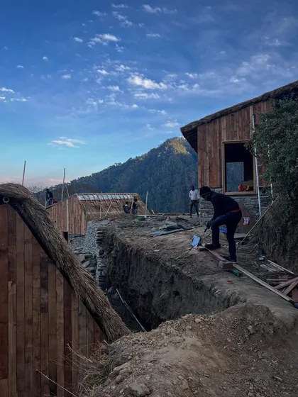 As construction nears completion, the forms of the guesthouses in Vasudev become clear. The buildings feature locally sourced thatch roofs and restored village home elements, creating a simple and functional stopover for travelers.