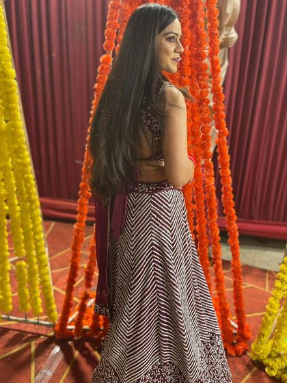 A candid shot of the client looking over her shoulder in the maroon chevron lehenga.