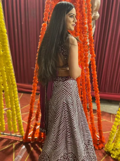 A candid shot of the client looking over her shoulder in the maroon chevron lehenga.