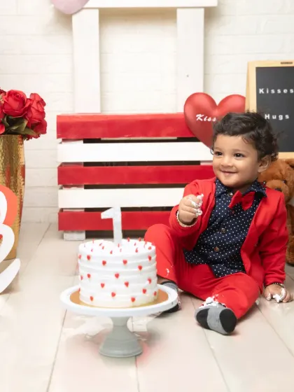 The perfect portrait with a heart-themed cake. This shot captures the full setup, from the red crate background to the love-themed props.
