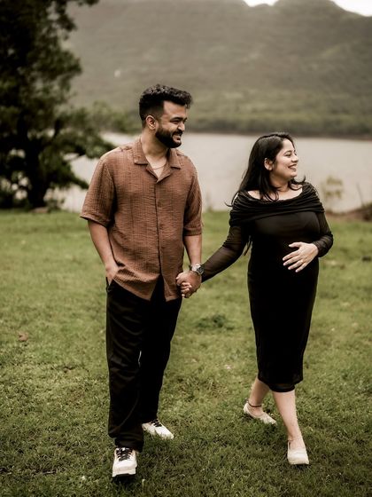 A happy, candid shot of the couple walking hand-in-hand by a lake. Their smiles and easy stride show the joy of taking this next step together.