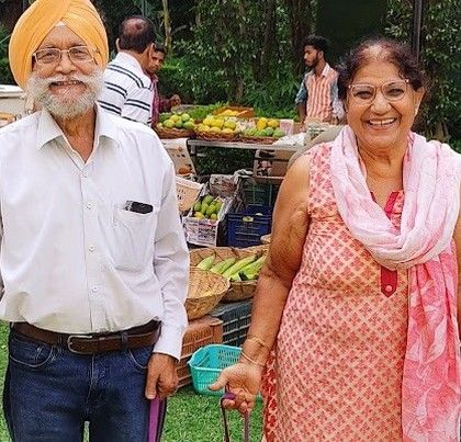 A smiling couple, regular shoppers, who represent the loyal community of the market.