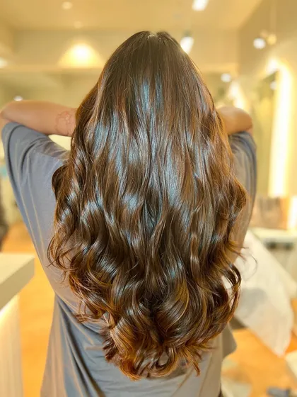 Sunkissed caramel brown balayage gives a warm, natural glow. The waves add dimension and show off the beautiful blend of colors.