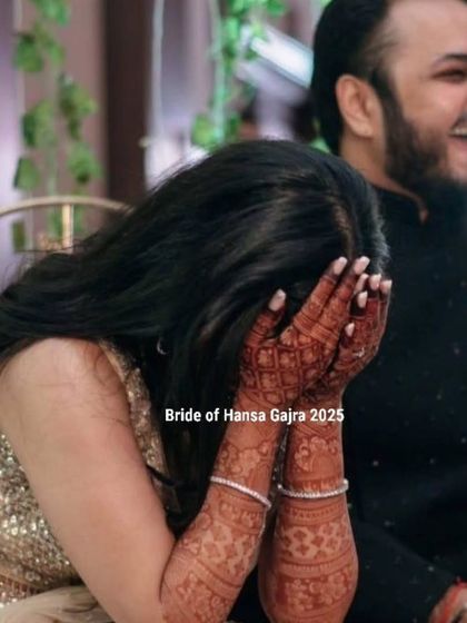 A candid moment of overwhelming happiness. The bride hides her face in her hands, a gesture of pure, uninhibited joy during her celebration.
