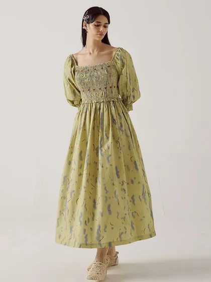 A full-length shot of the Smocked Dress from Cord, showcasing its elegant silhouette against a clean studio background.