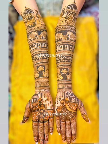 This full-length bridal design tells a story with a varmala scene on the palms and a royal procession of elephants on the arms.