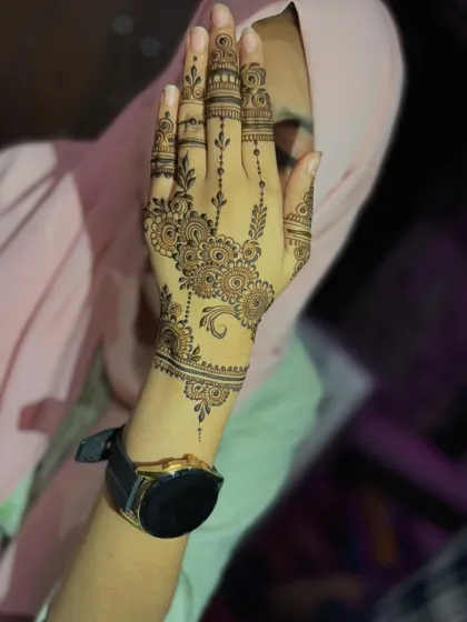 A lovely party henna design with delicate floral chains and detailed finger work. It's light, airy, and perfect for any occasion.