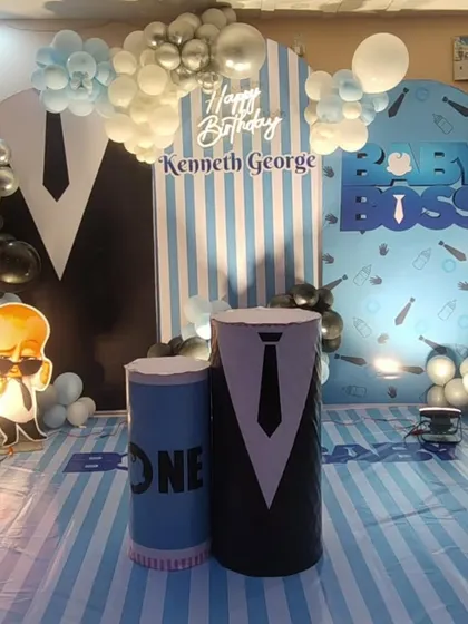 Who's the boss? For this first birthday, we created a fun Boss Baby theme. The setup includes a custom backdrop with the birthday boy's name, character cutouts, and themed pedestals, all framed by a stylish black, white, and blue balloon arrangement.